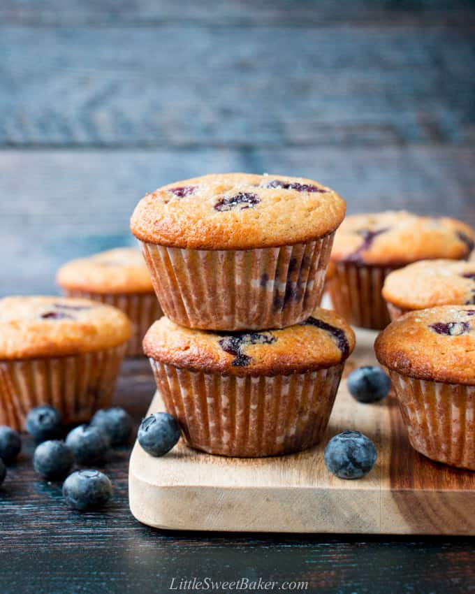 Healthy blueberry muffins with fresh blueberries around them.