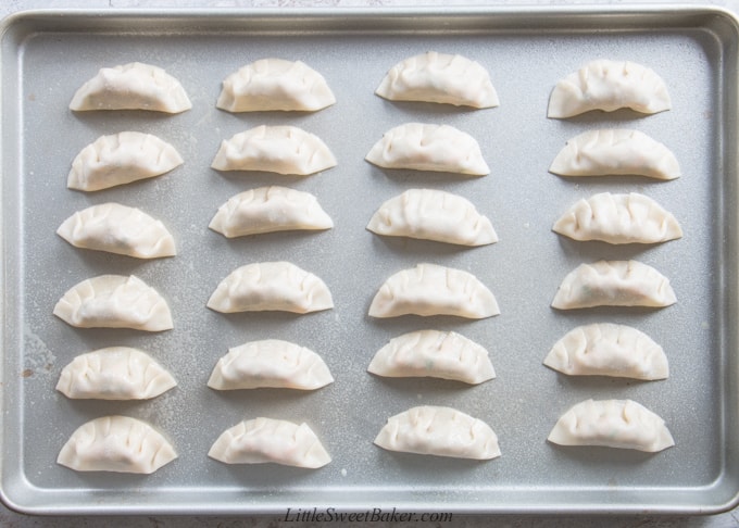 a pan of Chinese dumplings ready to be baked