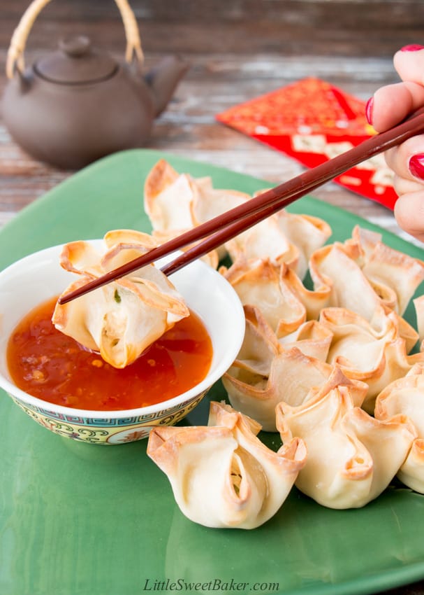 A plate of baked turkey rangoon with one being dipped in sweet chili sauce.