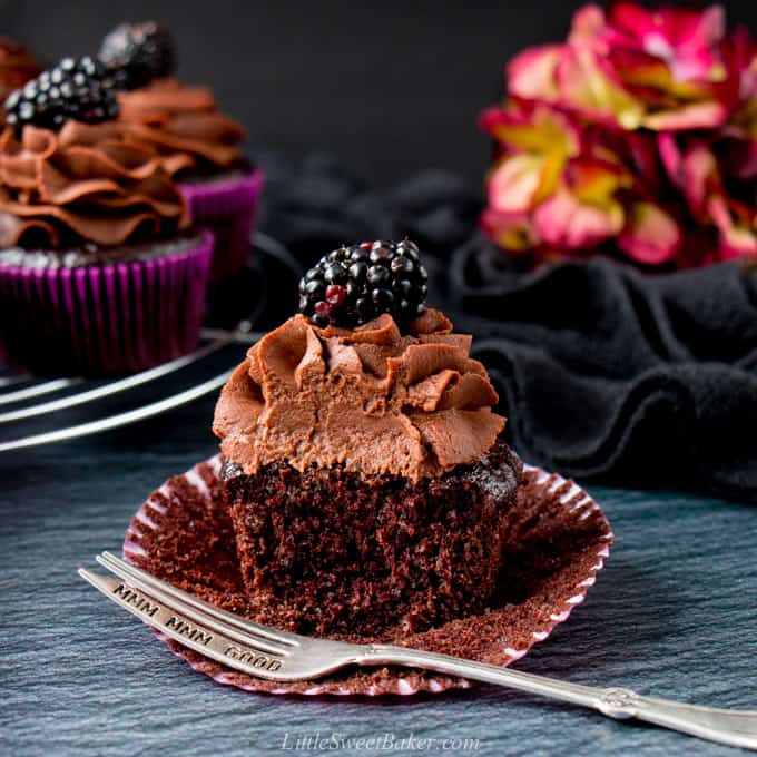 A half eaten easy moist chocolate cupcake topped with chocolate ganache.