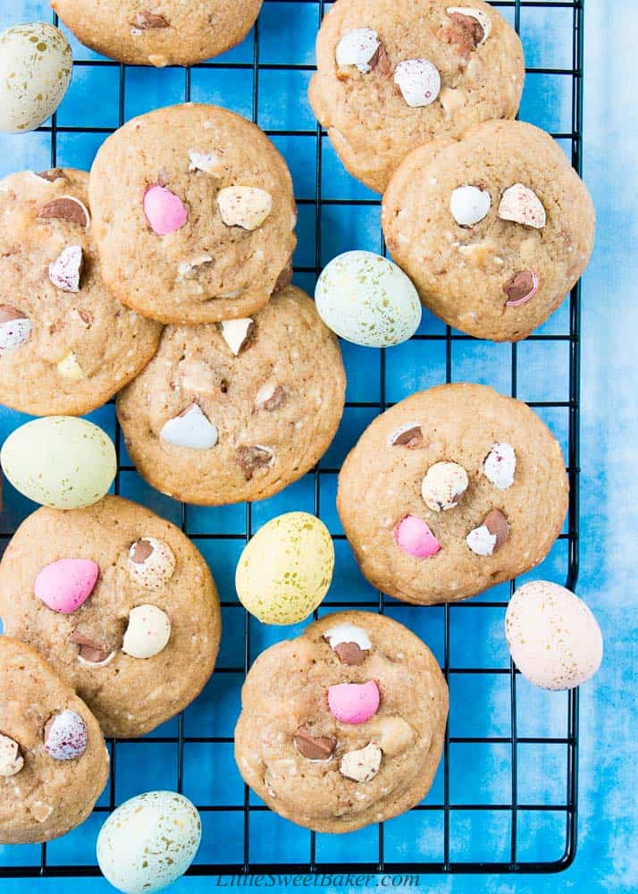Mini egg cookies on a cooling rack with speckled Easter eggs.