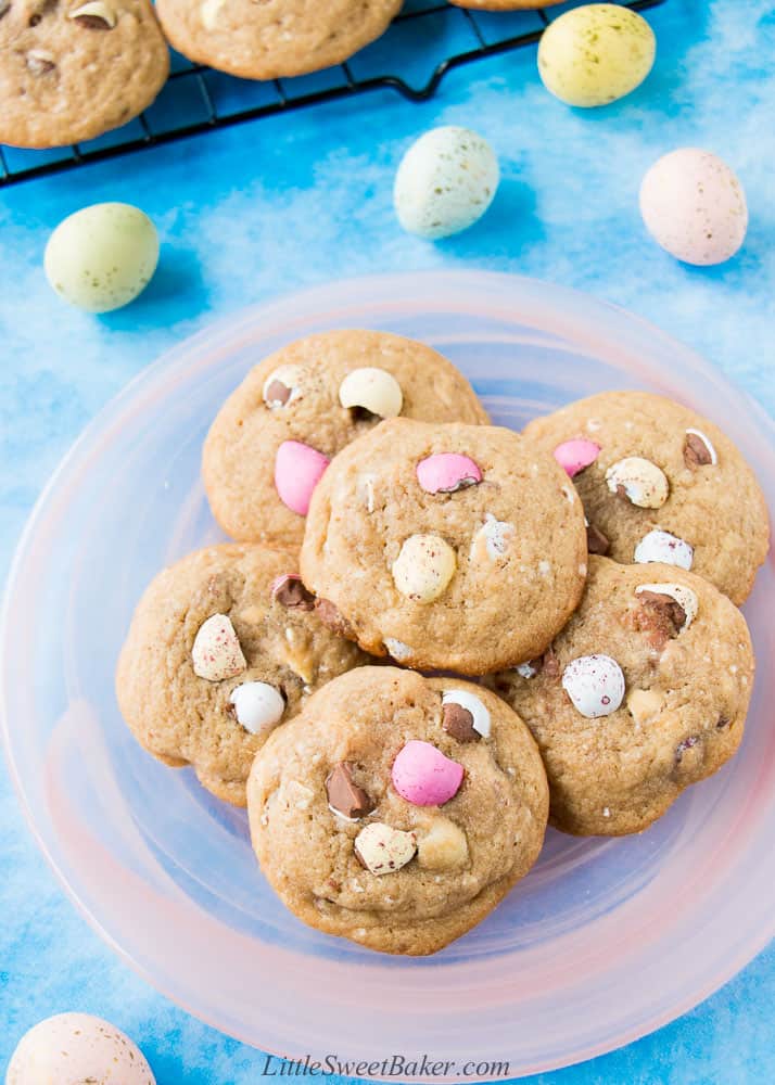 A pink plate of Cadbury mini egg cookies on a bright blue background.