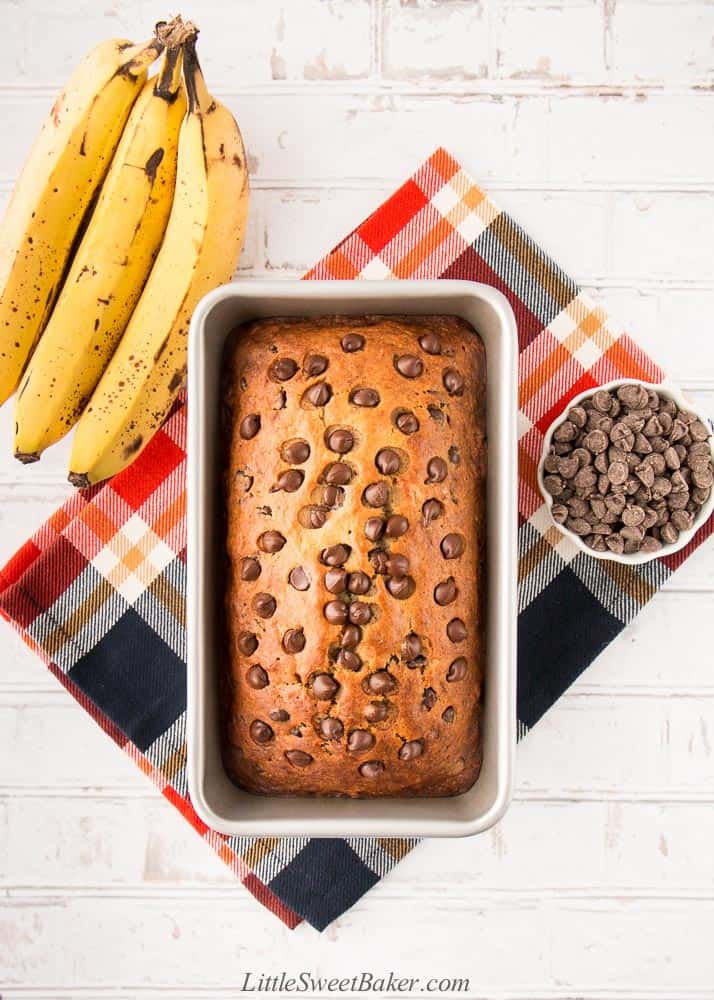 A loaf of chocolate chip banana bread on a plaid napkin