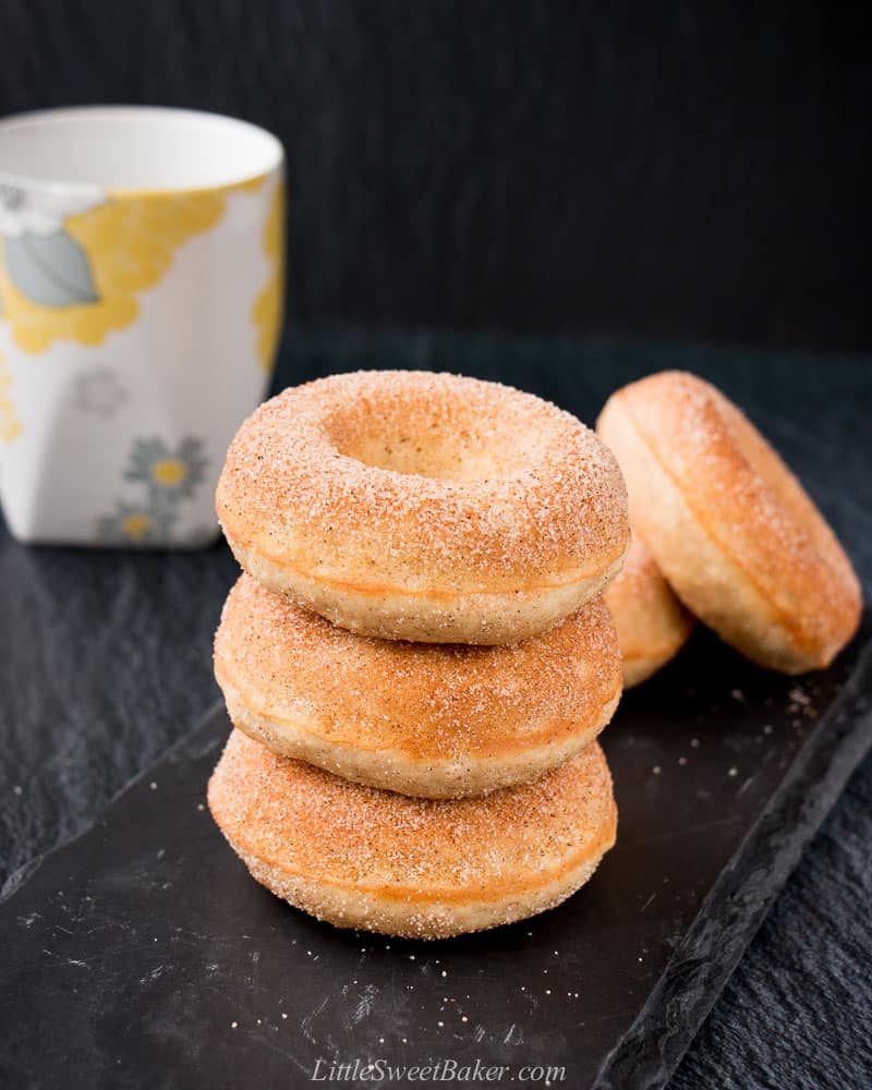 A stack of old-fashioned donuts on a piece of black slate.