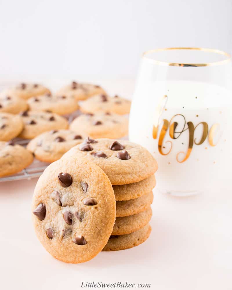 A stack of chocolate chip cookies with a glass of milk.