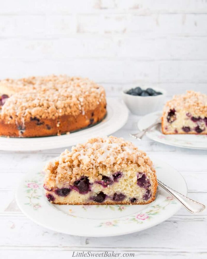 A slice of blueberry coffee cake on a vintage floral plate.