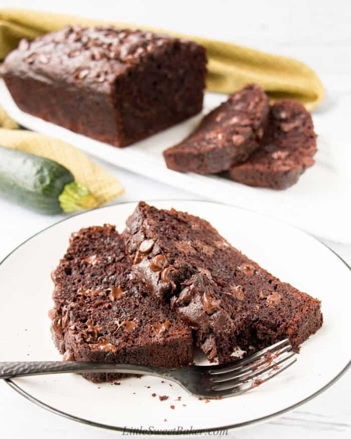 Two slices of chocolate zucchini bread on a white plate.