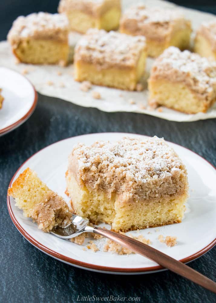 A slice of crumb cake on a plate with a fork.
