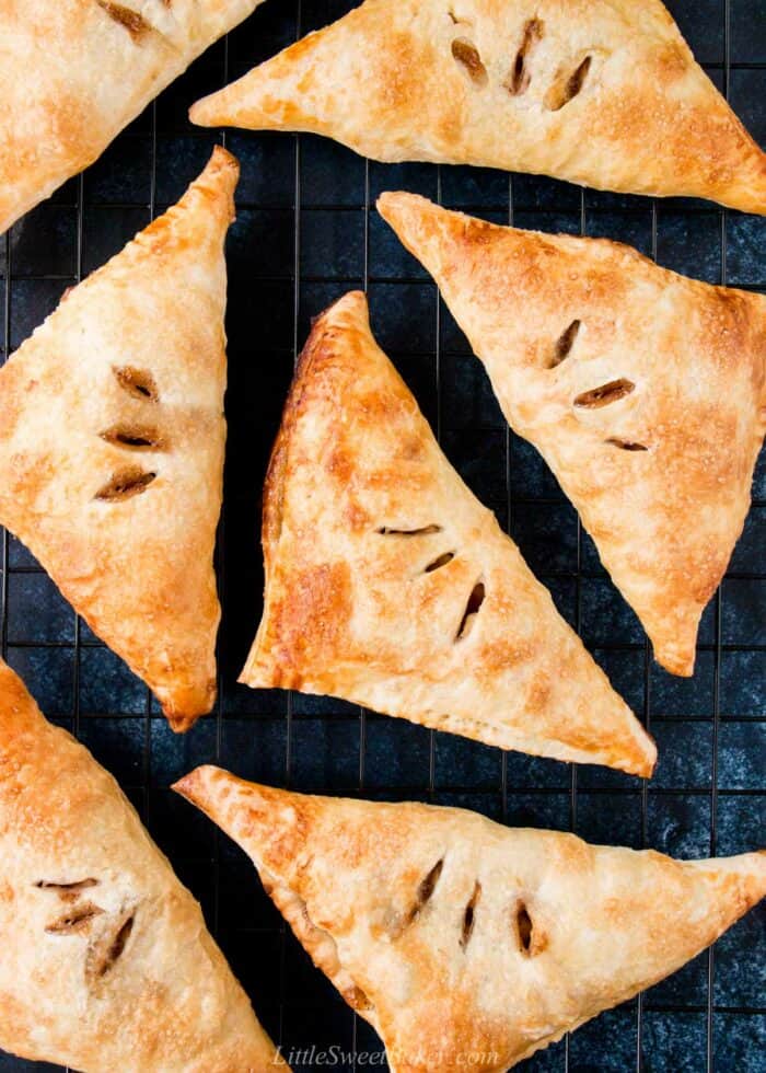 Puff pastry apple turnovers on a cooling rack.