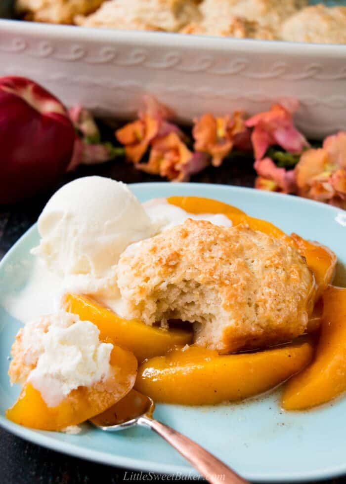 Peach cobbler served with ice cream on a light blue plate.