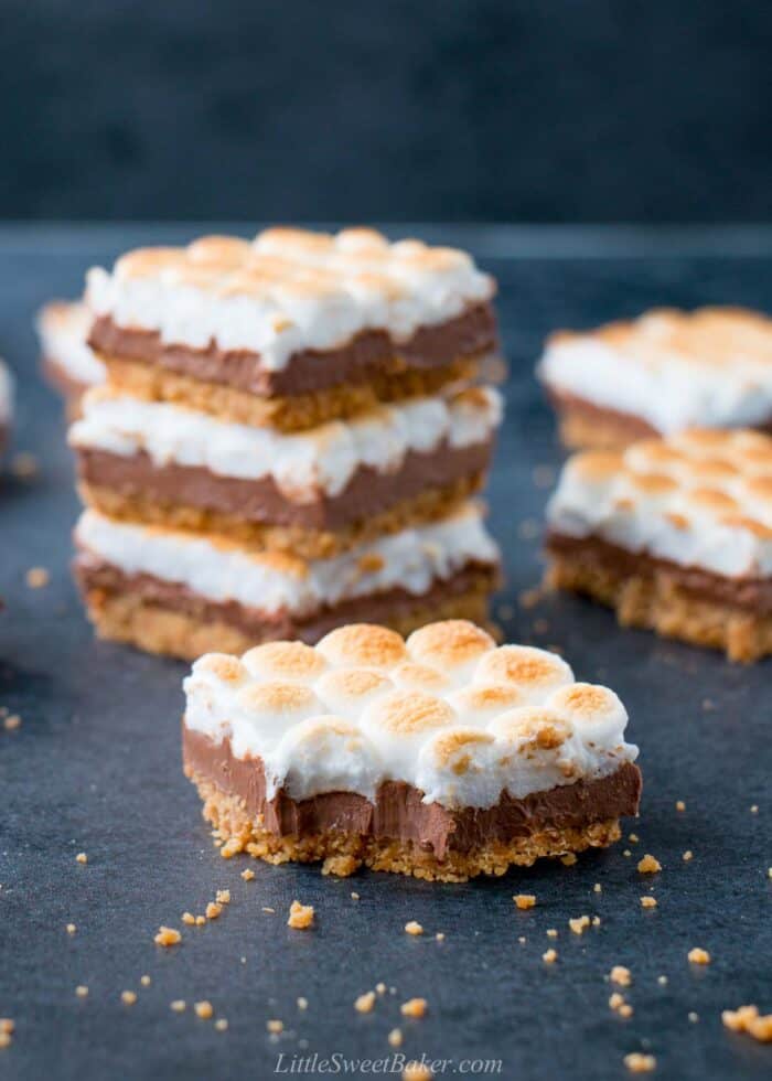 A s'mores bar on a dark blue surface with a bite taken out.