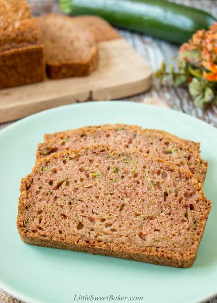 Two slices of zucchini bread on a light green plate.