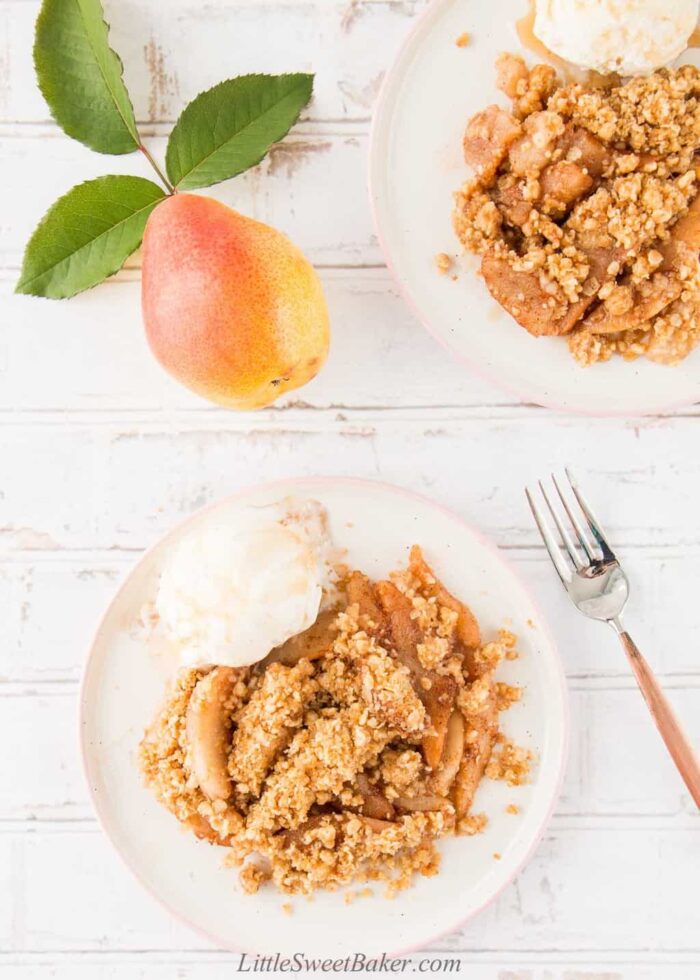 Two plates of pear crisp with ice cream.