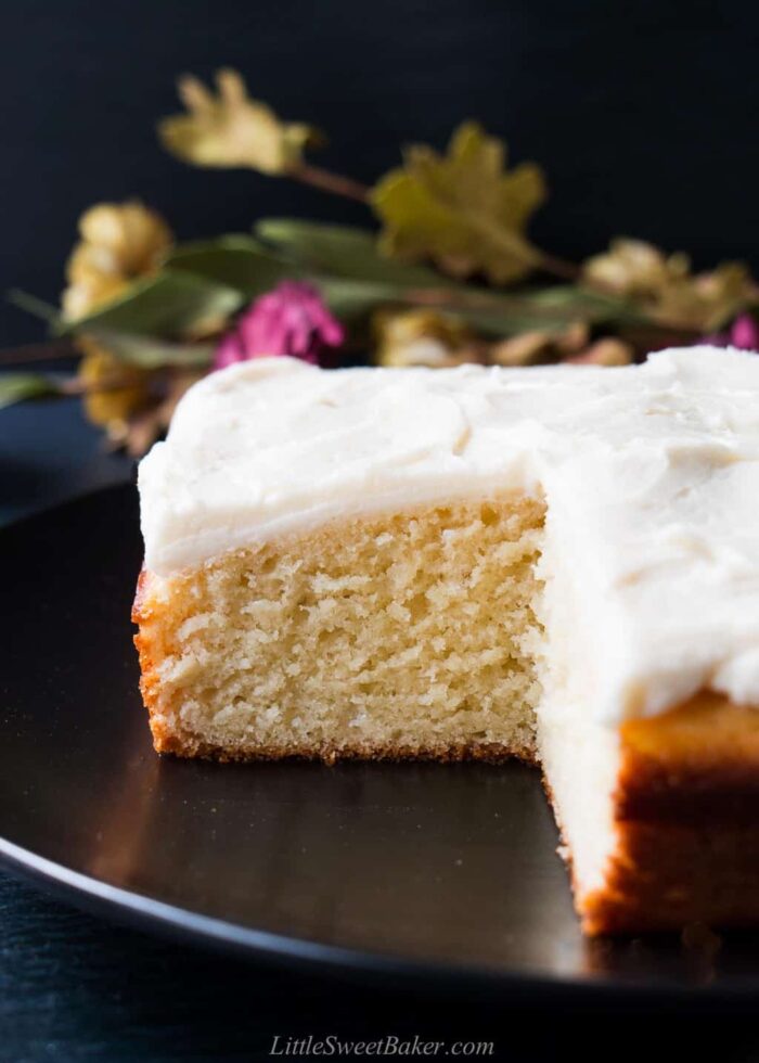 A vanilla snack cake on a black plate.