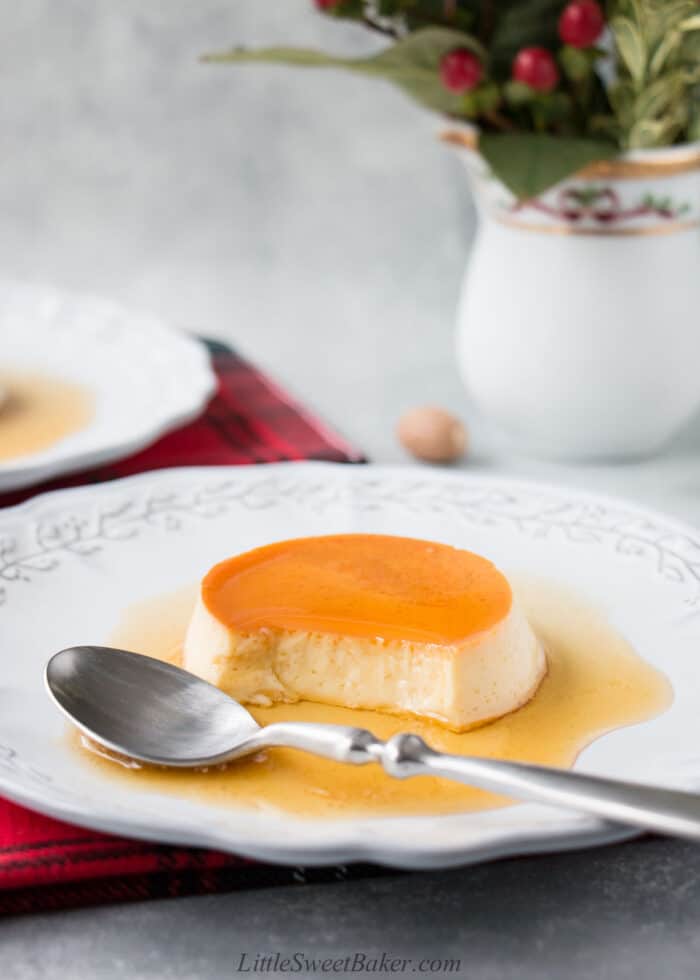 eggnog creme caramel on a light gray plate with spoon.