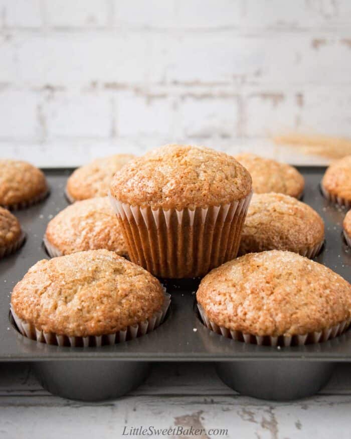 Banana muffins in it's baking pan with one on top.