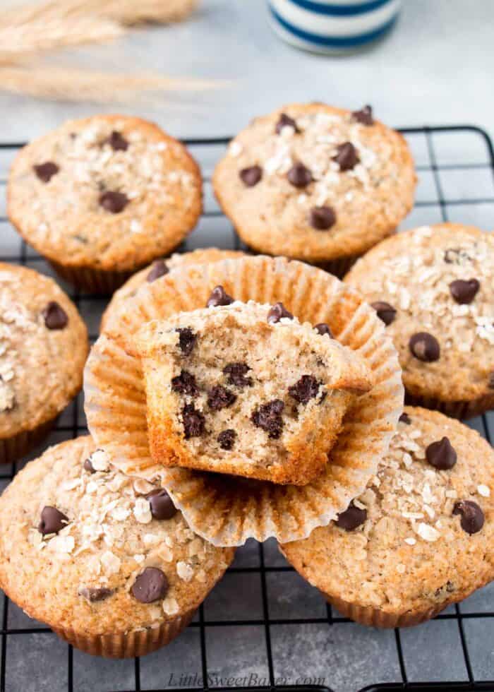 Oatmeal chocolate chip muffins on a cooling rack with a big bite taken out of one.