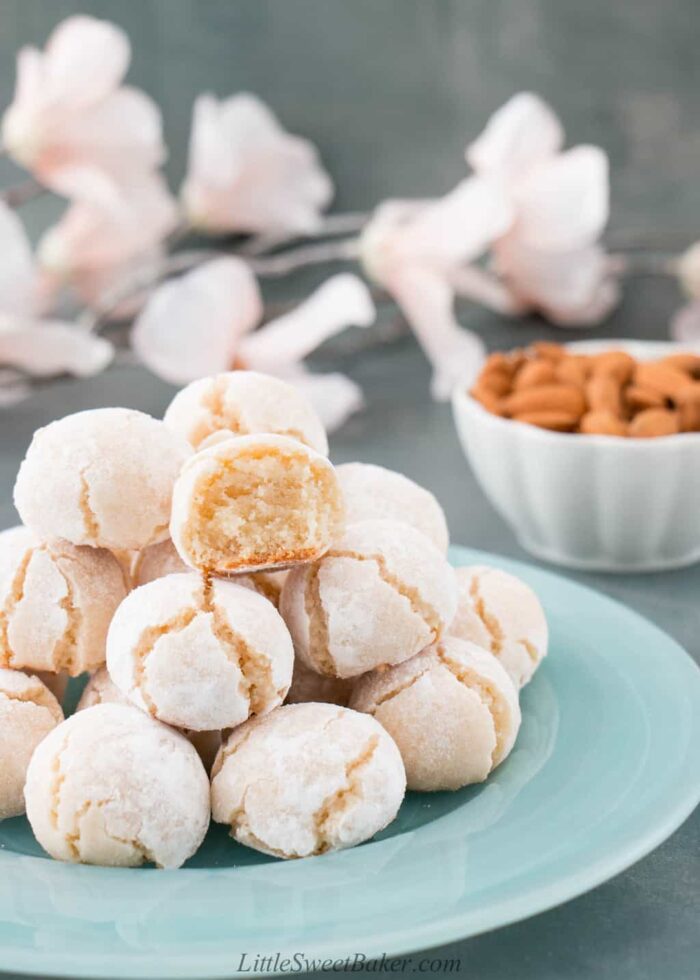 A plate of amaretti cookies with a bite taken out of one.