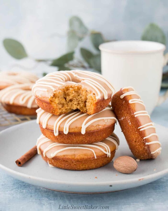 A stack of sweet potato donuts with a bite taken out of the top one.