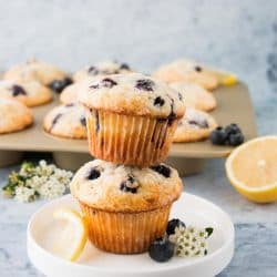 Two blueberry lemon muffins staked on a white plate.