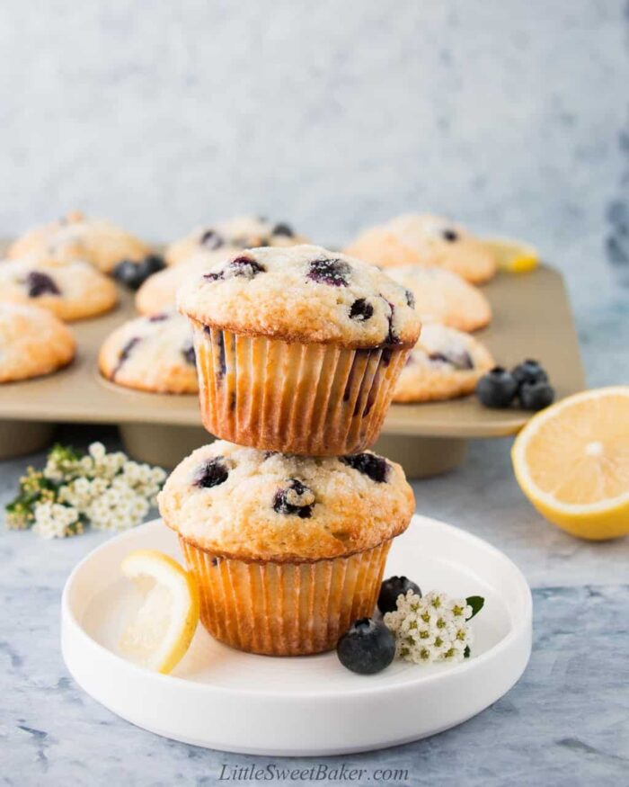 Two blueberry lemon muffins staked on a white plate.