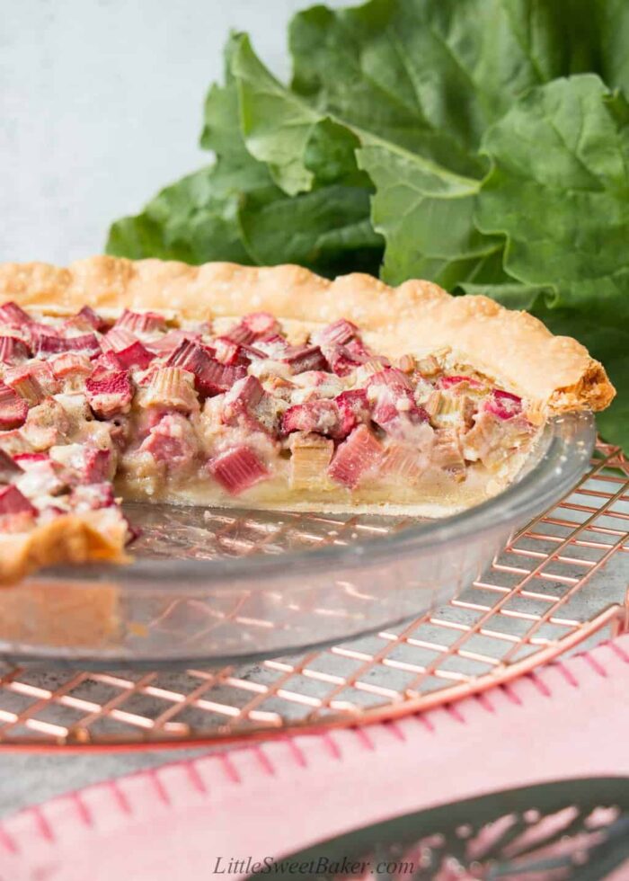 An eye-level view of a rhubarb custard pie with a slice cut out.