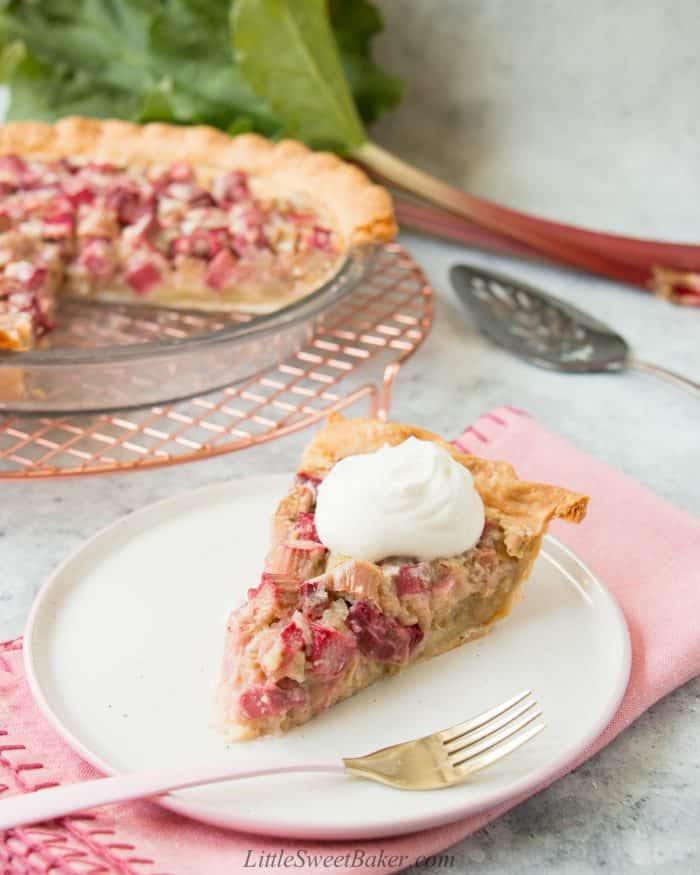 A slice of rhubarb custard pie with a dollop of whipped cream.