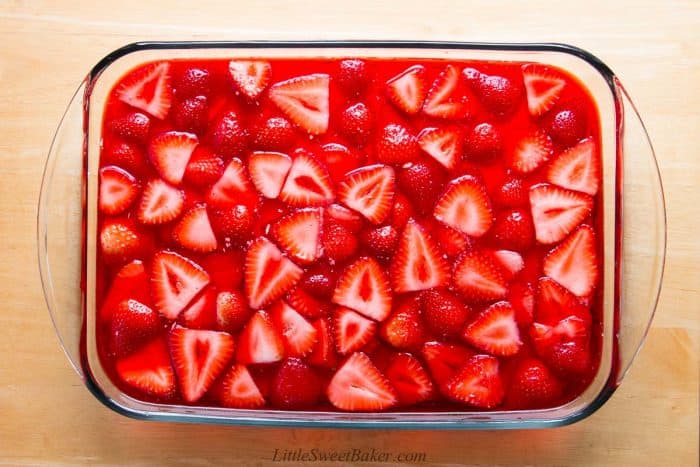 Jello and fresh strawberry top layer for pretzel salad dessert.