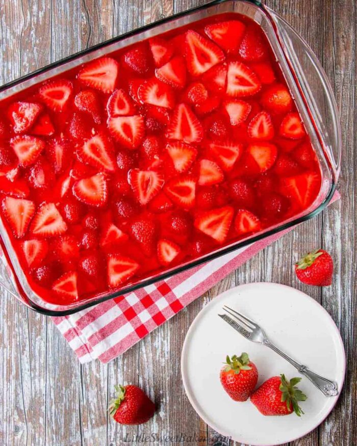 An overhead view of strawberry pretzel salad dessert on a wooden surface.