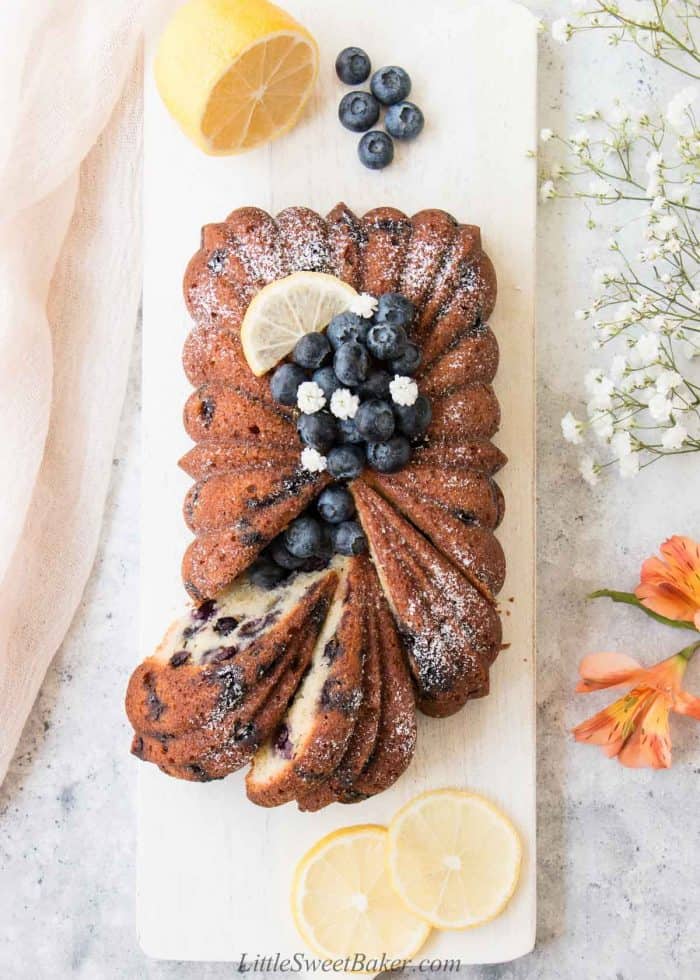 A loaf of lemon blueberry pound cake on a white board.