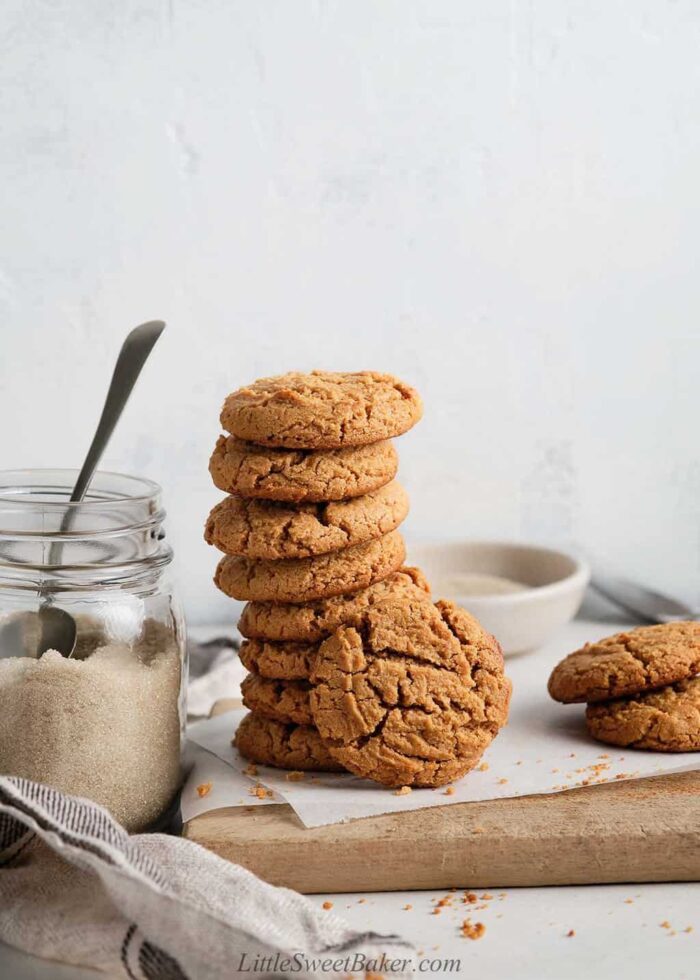 A stack of healthy peanut butter cookies on a wooden board.