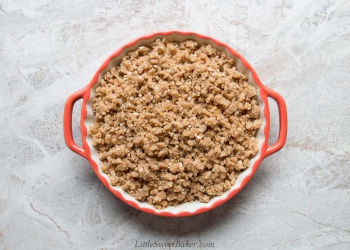 Unbaked peach crisp in a ceramic dish.