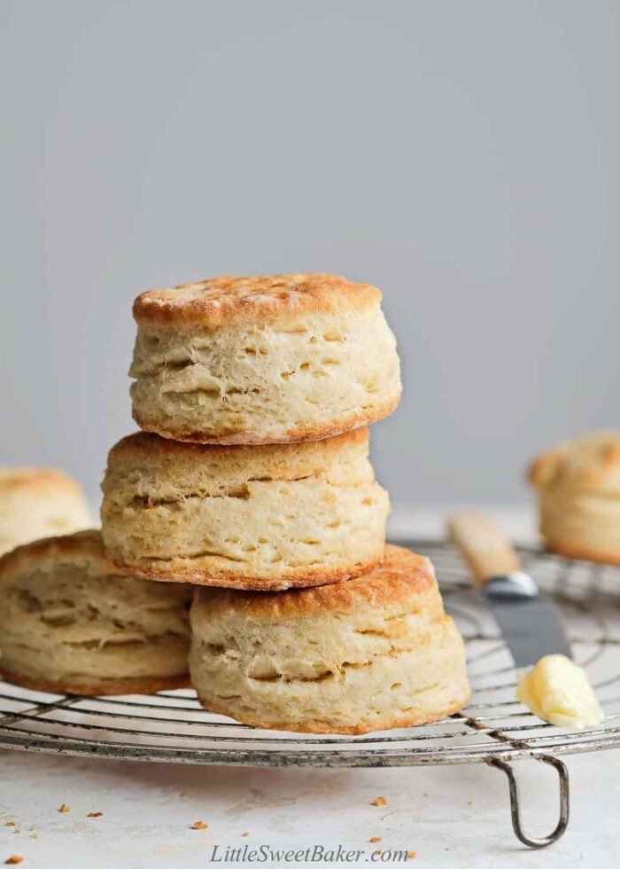 A stack of flaky butter biscuits on a cooling rack.