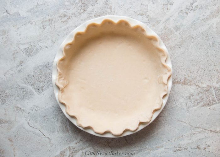 An unbaked pie shell with crimped edges.