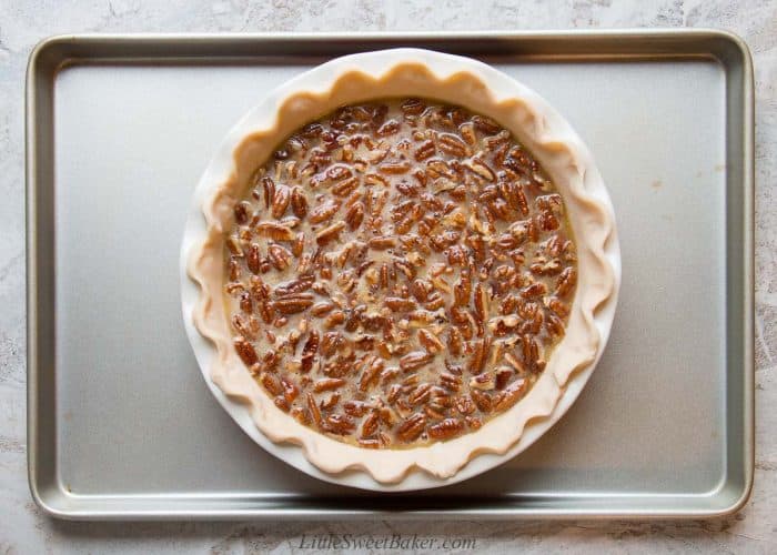 An unbaked pecan pie on a cookie sheet.