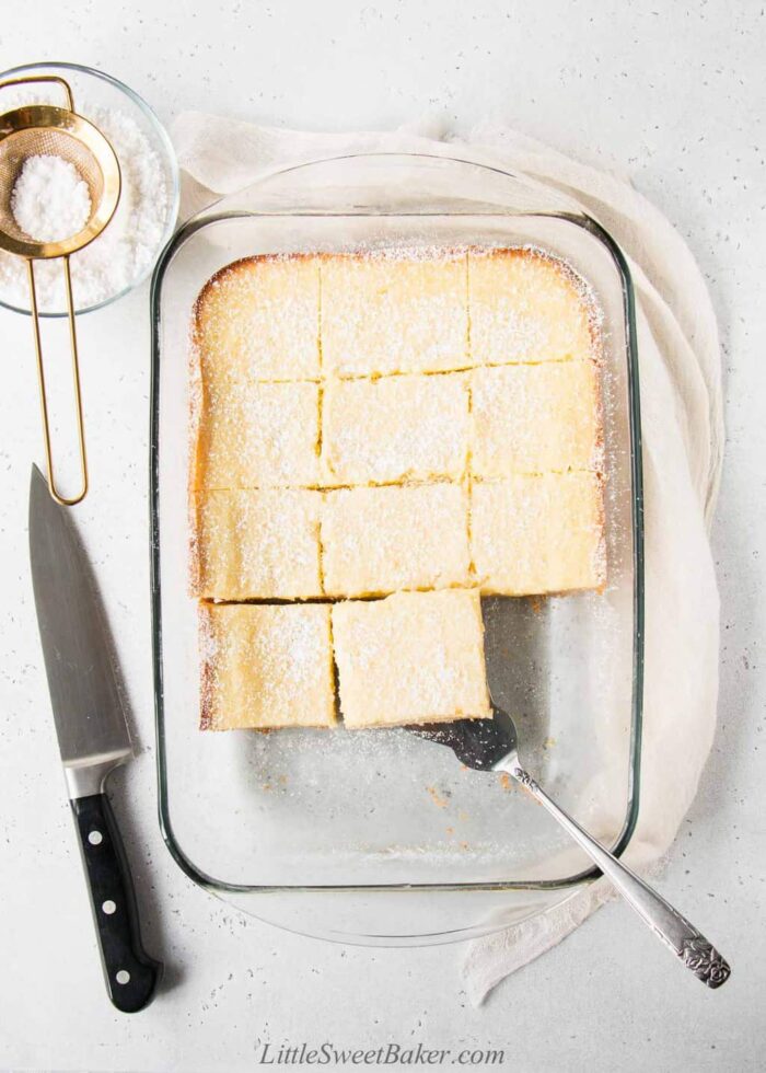 Sliced gooey butter cake in a glass baking dish.