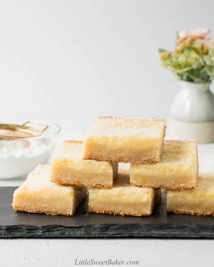 A stack of gooey butter cake on a black slate serving board.