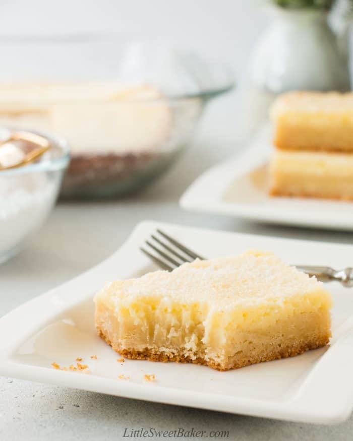 A slice of gooey butter cake with a bite taken out of it.