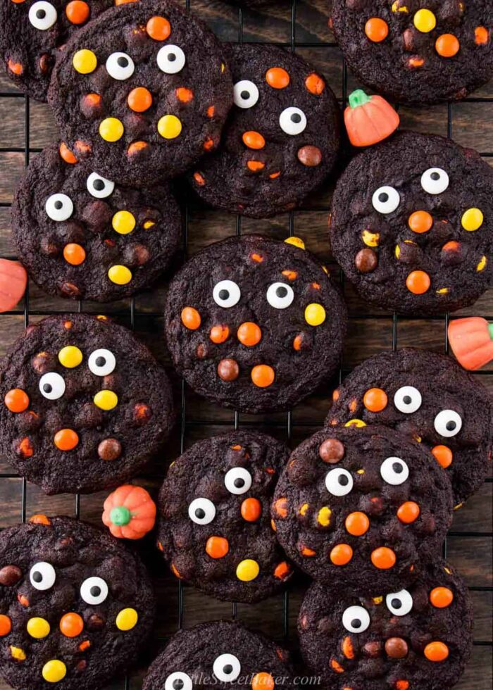 An overhead view of chocolate Reese's Pieces Halloween cookies on a cooling rack.