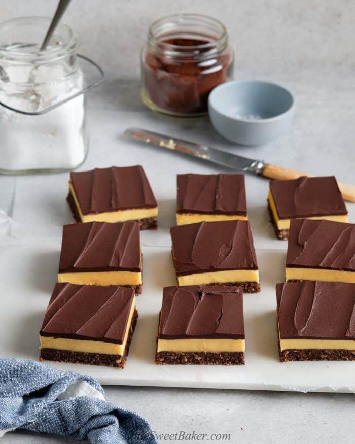 Cut Nanaimo bars on a sheet of wax paper and marble cutting board.