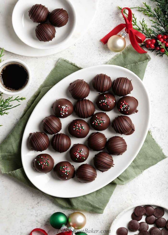 Chocolate-covered peanut butter balls on a white oval plate.