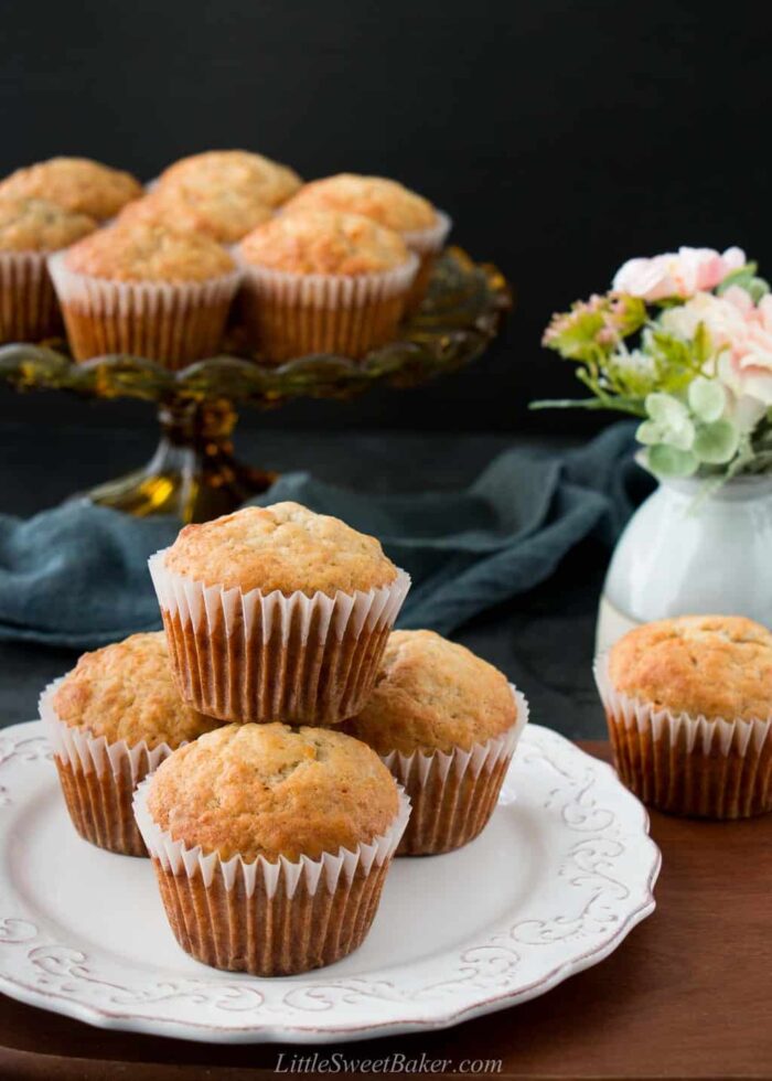 Banana bread muffins on a white plate and on a cake stand in the background.