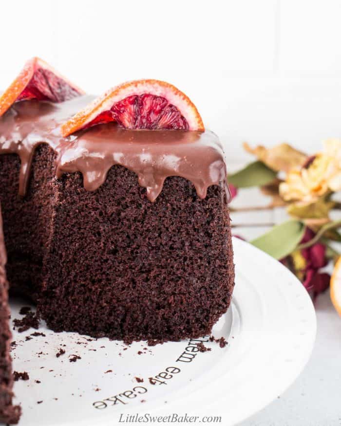 Chocolate chiffon cake topped with chocolate sauce on a white plate.