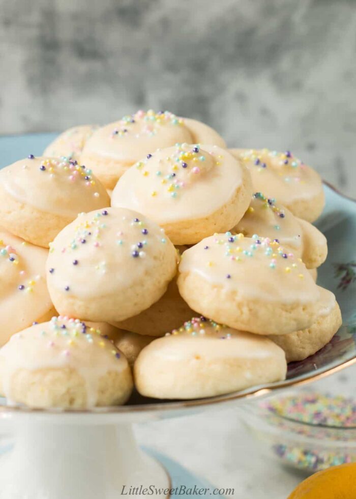 A cake stand of Italian Easter cookies topped with glaze and pastel nonpareils.