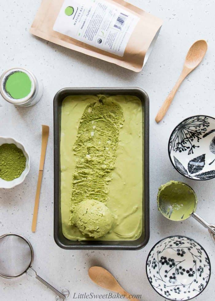 No-churn matcha ice cream in a loaf pan with one scoop rolled out.