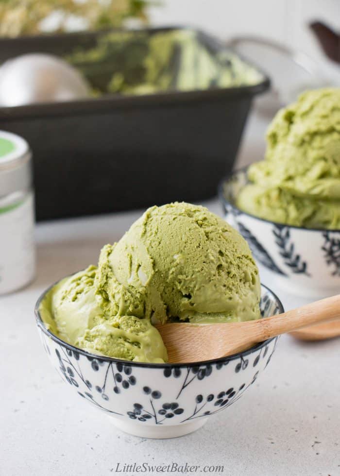 A bowl of matcha ice cream with a wooden spoon.