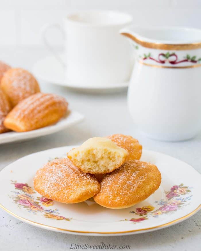 A plate of madeleine cookie with one bitten.