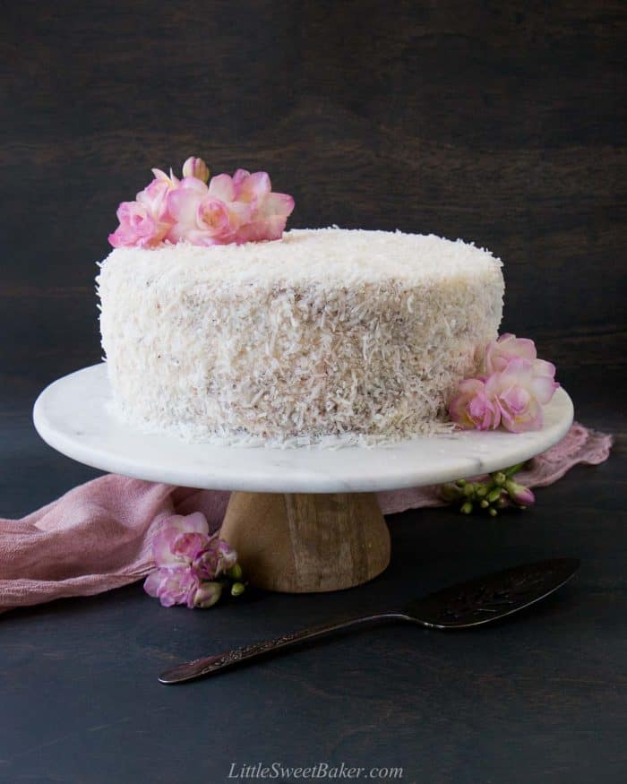 Ube cake with coconut frosting on a marble cake stand