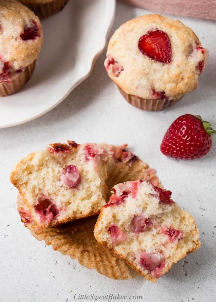 A strawberry muffin broken in half to show the inside texture.