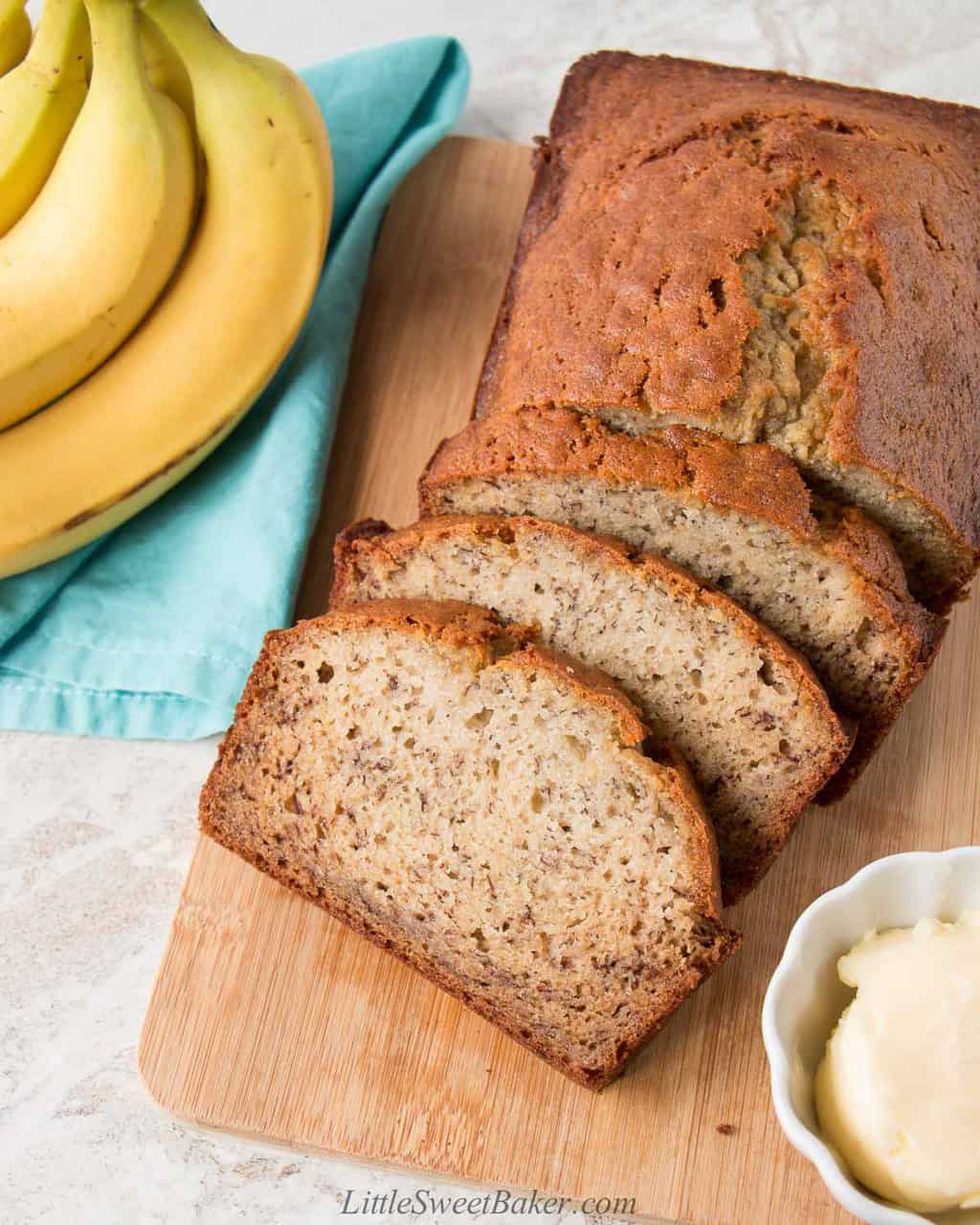 Banana bread on a cutting board with three slices cut.